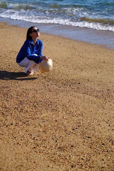 Genç bir kadın Portekiz, Porto 'da kumlu ve mavi gökyüzü olan boş bir kumsalın keyfini çıkarıyor..