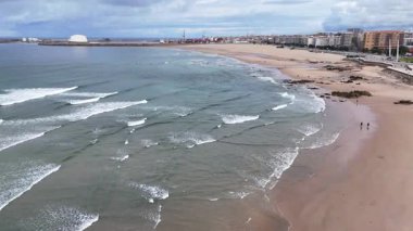 Portekiz plajı - Atlantik Okyanusu 'ndaki kumlu Matosinhos plajının havadan çekilmiş bir görüntüsü. Sahildeki dalgaların üzerinde alçaktan uçuyor.
