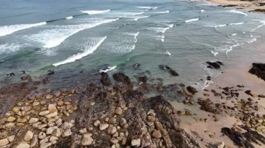Portekiz plajı - Atlantik Okyanusu 'ndaki kumlu Matosinhos plajının havadan çekilmiş bir görüntüsü. Sahildeki dalgaların üzerinde alçaktan uçuyor.