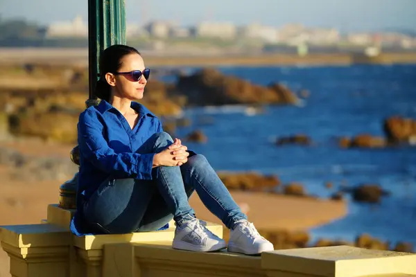 Gün batımında gezinen kadın, Pergola Foz, Portekiz 'de denizin yanında.