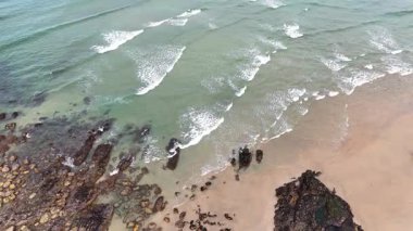 Portekiz plajı - Atlantik Okyanusu 'ndaki kumlu Matosinhos plajının havadan çekilmiş bir görüntüsü. Sahildeki dalgaların üzerinde alçaktan uçuyor.