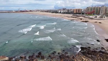 Portekiz plajı - Atlantik Okyanusu 'ndaki kumlu Matosinhos plajının havadan çekilmiş bir görüntüsü. Sahildeki dalgaların üzerinde alçaktan uçuyor.
