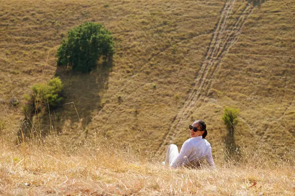 Çekici bir kız rüzgar, gülümseme ve özgürlükten, gün batımından ve sonbahar ışığından hoşlanır. Güzel bayan doğada eğleniyor..