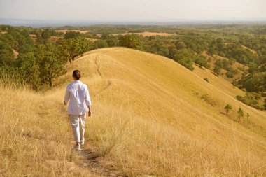 Çekici bir kız rüzgar, gülümseme ve özgürlükten, gün batımından ve sonbahar ışığından hoşlanır. Güzel bayan doğada eğleniyor..