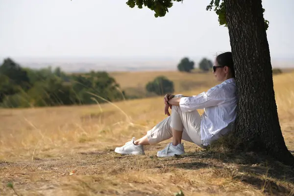 Çekici bir kız rüzgar, gülümseme ve özgürlükten, gün batımından ve sonbahar ışığından hoşlanır. Güzel bayan doğada eğleniyor..