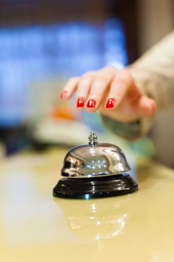 Gümüş servis çanlarını çalan bir kadın el.