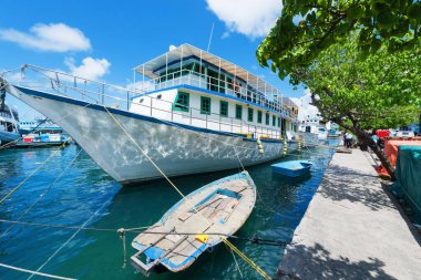 Limanda motorlu gemi var. Arka planda tanınmayan insanlar var.