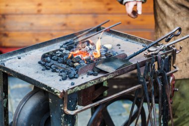 Geleneksel demirci ocağına yakın çekim kömürleri, metal yüzeyinde aletler