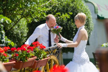 Gülümseyen gelin, damada çiçek sunuyor.