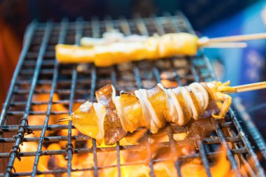 Kalamar halkaları barbekü ızgarası, duman görüntüde mümkün.