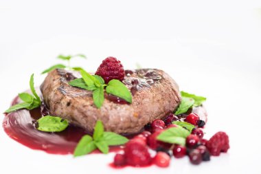 Tabakta orman meyvesi soslu biftek. Kapatın. Beyaz arkaplan