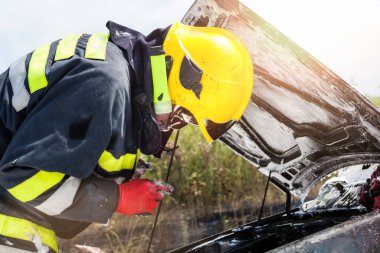 İtfaiyeci arabada yangınla boğuşuyor.
