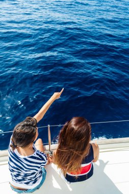 Bir yelkenlinin pruvasında mutlu kadınlar. 