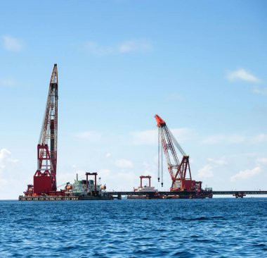 Güneşli bir günde suyun üzerinde yüzen vinç