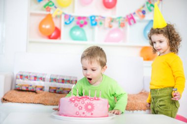 Doğum günü pastasında mumları söndüren çocuklar. Doğum günü partisi