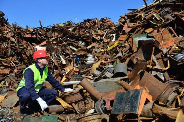 Güneşli bir günde hurdalıkta çalışan bir işçi