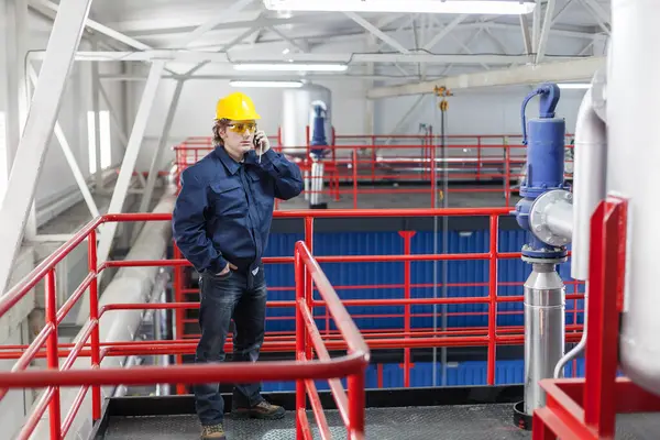 İş yerindeki işçiler fabrikanın içinde cep telefonu kullanırlar.