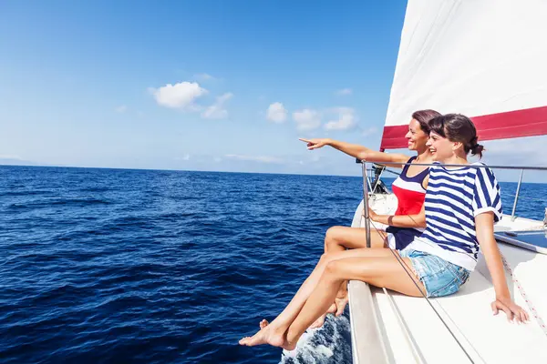 Yelkenli teknenin pruvasındaki mutlu kadınlar bir şeyi işaret ediyor.