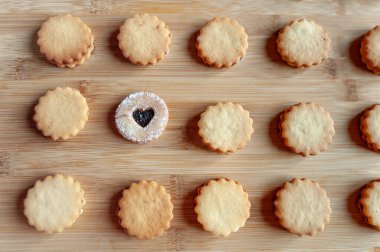 Bambu kalasların üzerine dizilmiş ev yapımı kurabiyeler. Bir tanesi farklı..