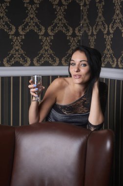 Güzel, şehvetli esmer ve bir bardak şampanyası olan,