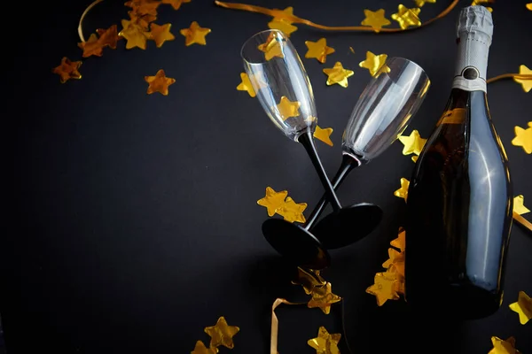 Ποτήρια Και Μπουκάλι Σαμπάνια Χρυσές Σερπεντίνες Και Κομφετί Ξαπλωμένα Μαύρο — Φωτογραφία Αρχείου