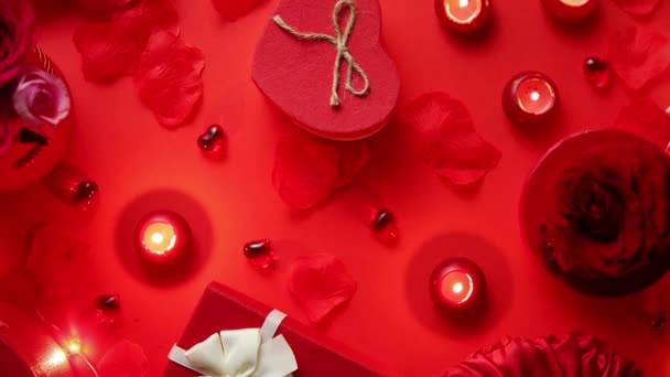 箱入りギフト 赤の背景にテーブルの上の蝋燭とバレンタインの日ロマンチックな装飾 コピー スペース平面図 — ストック動画