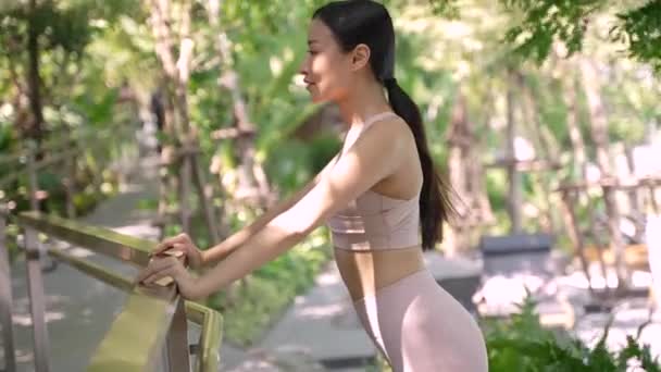 Nuori Thaimaalainen Aikuinen Venyttelee Ulkona Puistossa Pukeutuu Urheilullisiin Vaatteisiin Näyttää — kuvapankkivideo