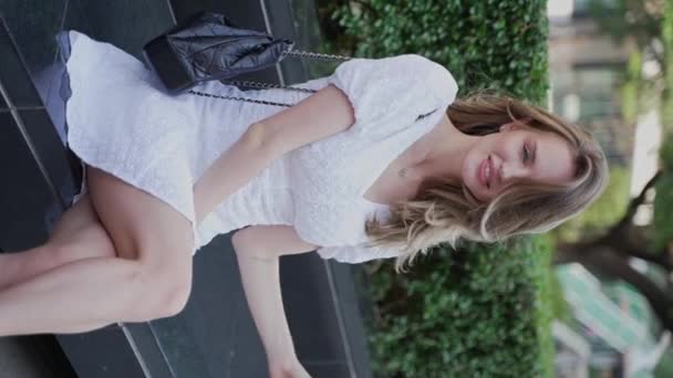 Блондинка Сидящая Городском Парке Улыбающаяся Наслаждающаяся Летним Днем — стоковое видео