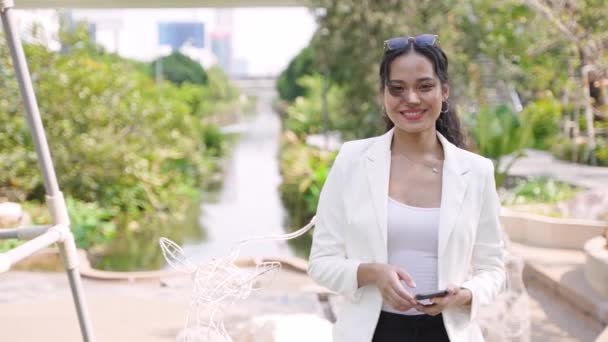 美丽的笑着的亚洲女人在城市的街道或公园里使用手机 — 图库视频影像