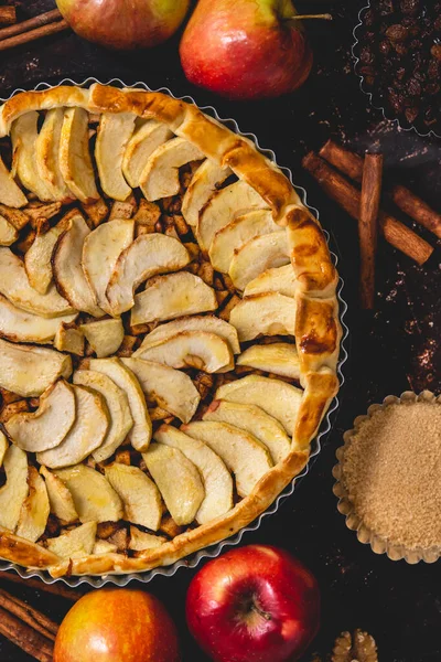 黒を基調においしいパイの周りに配置された芳香族スパイスやリンゴのトップビュー ストック画像