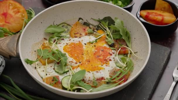 おいしい朝食 フライパンに野菜を添えた2個の揚げ卵 — ストック動画