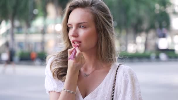 Μια Γυναίκα Βάζει Κραγιόν Στα Χείλη Της Καθισμένος Αστικό Περιβάλλον — Αρχείο Βίντεο