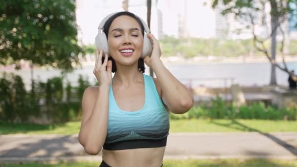 Uśmiechnięta Kobieta Słuchawkach Stroju Fitness Ciesząca Się Muzyką Przygotowując Się — Wideo stockowe