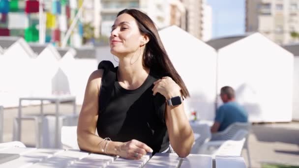 在西班牙 一位自信的中年妇女在咖啡馆的餐桌前放松下来 这里阳光明媚 城市的氛围非常适合休闲和生活方式的主题 — 图库视频影像