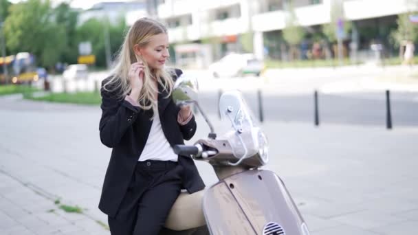 ビジネス衣装のエレガントな女性は 市内のレジャーの瞬間を楽しんで モータースクーターで休憩を取ります — ストック動画