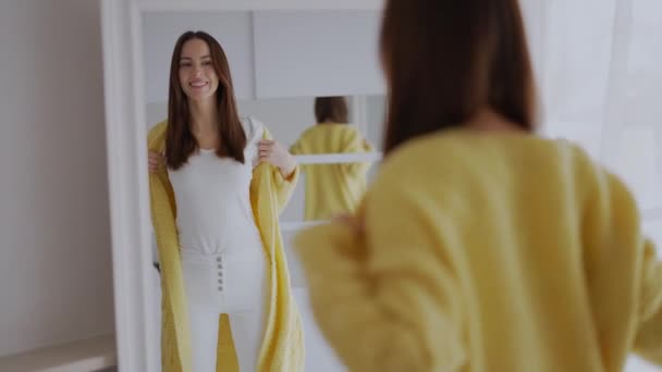 Jovem Alegre Admirando Espelho Vestindo Casaco Amarelo Brilhante Uma Sala — Vídeo de Stock