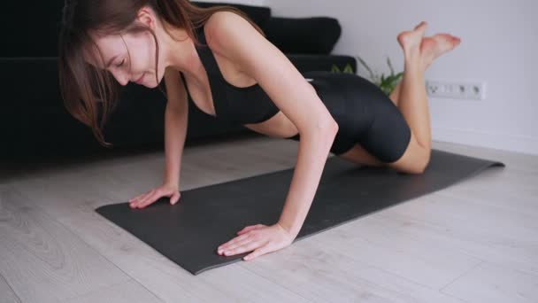 一位穿着运动服的年轻女士在宁静的家庭环境中 在垫子上练习瑜伽 以说明健康和健康 — 图库视频影像