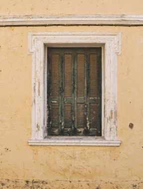 Yunanistan 'da terk edilmiş bir evin dış cephesinde kapalı pencerenin ayrıntıları