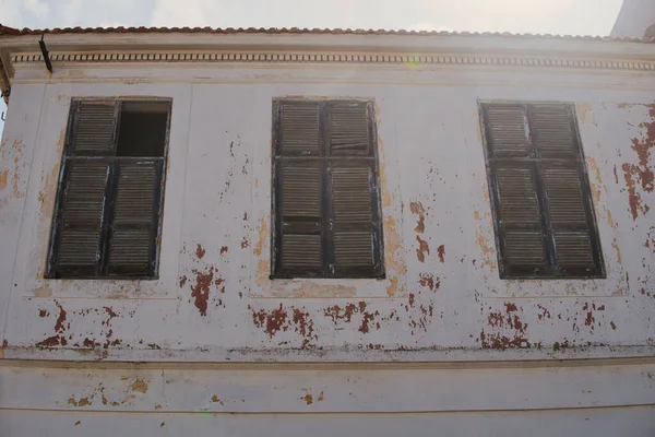 希腊一座废弃房屋正面有闭合百叶窗的旧窗户的细节 — 图库照片