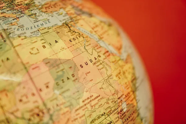 Detal Sudanu Modelu Globu Mapą Polityczną Czerwonym Tle — Zdjęcie stockowe