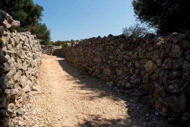Taştan yapılmış duvarlar arasında zemin yolu