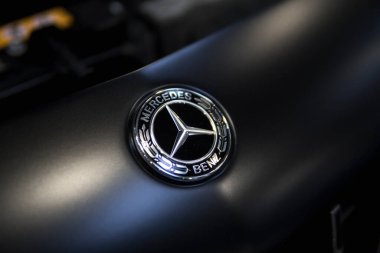 Siyah bir arabanın üzerindeki Mercedes Benz ambleminin ayrıntıları.