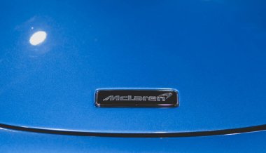 Siyah bir arabanın üzerindeki McLaren ambleminin ayrıntıları.