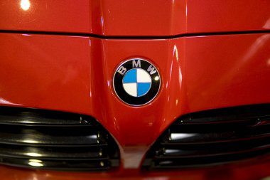 Kırmızı bir arabanın kaputundaki Ferrari ambleminin ayrıntıları.