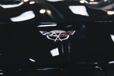 Siyah bir arabanın kaputunda Chevrolet amblemi var.