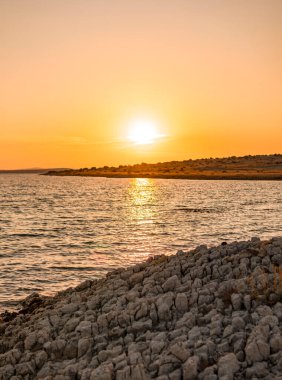 Yaz mevsiminde Akdeniz 'de adanın üzerinde gün batımı