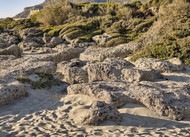 Kumlu bir sahilde aşınmış kireçtaşı kayaları