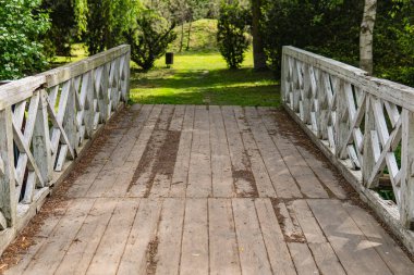 Old wooden bridge with white painted railings clipart