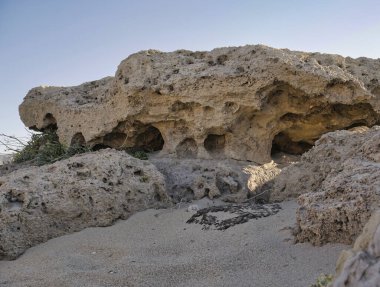 Kumlu sahildeki kireçtaşı kayalıklarına yakın.