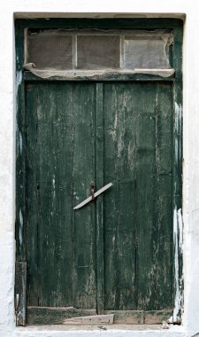 Yeşil ahşap kapılı eski bir binanın beyaz duvarı.